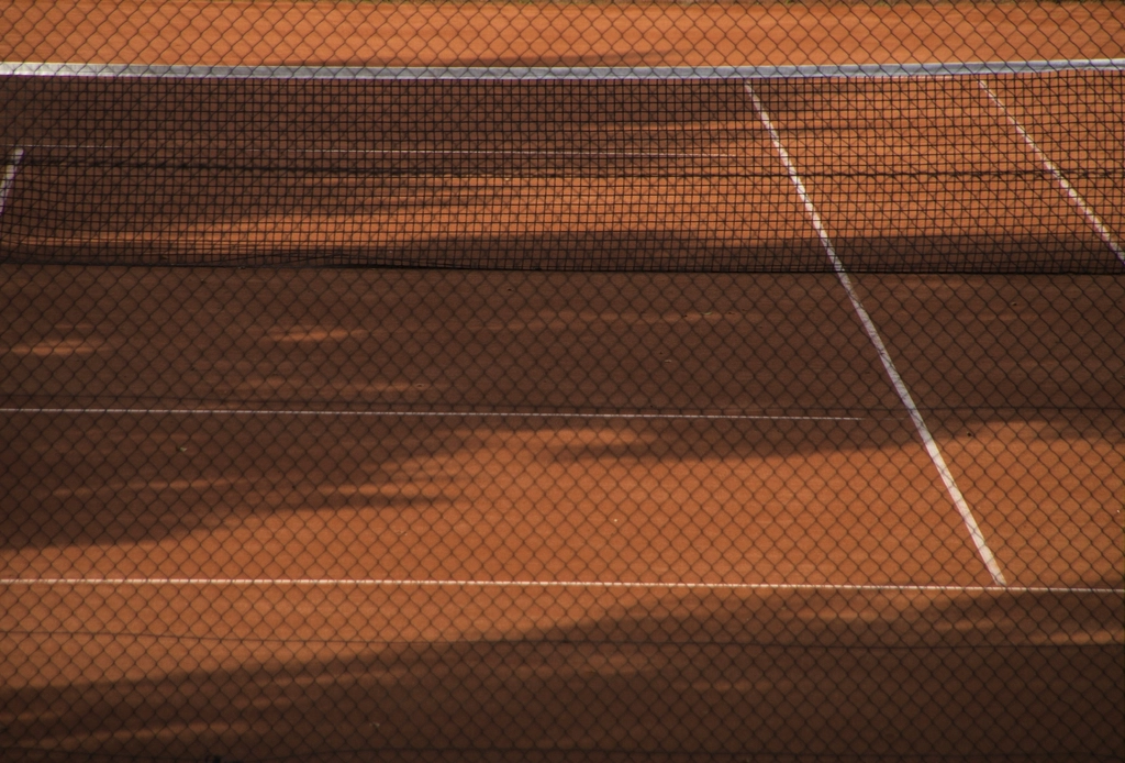Empty tennis court with white lines and net